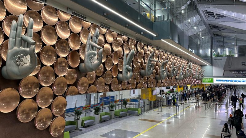 Nine hands form "murdras"" or traditional hand gestures on the wall mural in the arrivals hall of Terminal 3 of Indira Gandhi International Airport in New Delhi March 9, 2024. They are offset by copper discs.