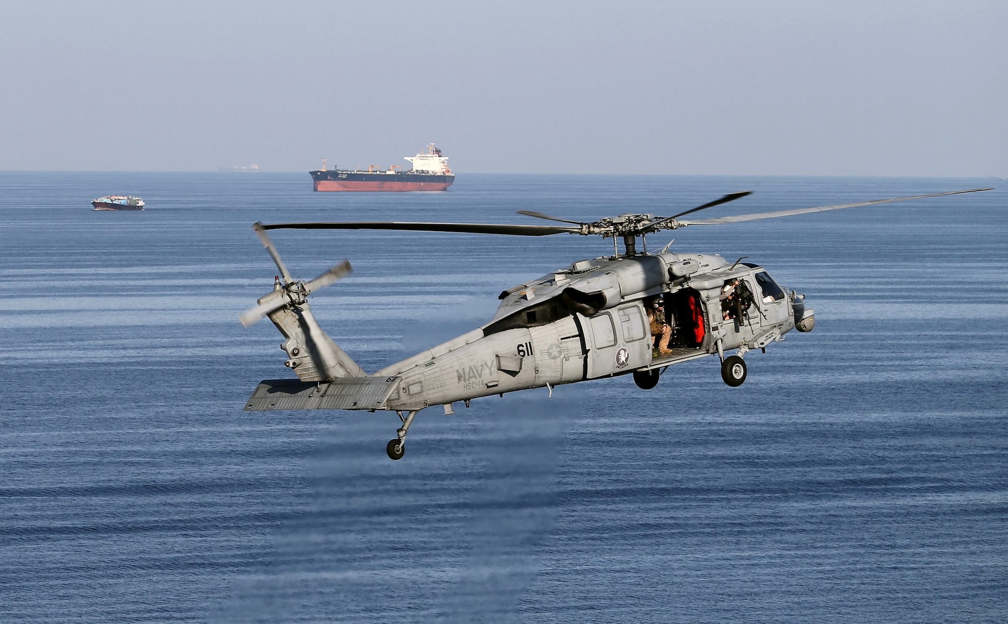 A US military helicopter escorts a vessel in the Strait of Hormuz. The US has facilities at Al Udeid Air Base in Qatar