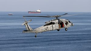 A US military helicopter escorts a vessel in the Strait of Hormuz. The US has facilities at Al Udeid Air Base in Qatar