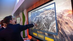 Businessmen watch an on-screen presentation of Saudi Arabia's Trojena project at the Mipim in Cannes.