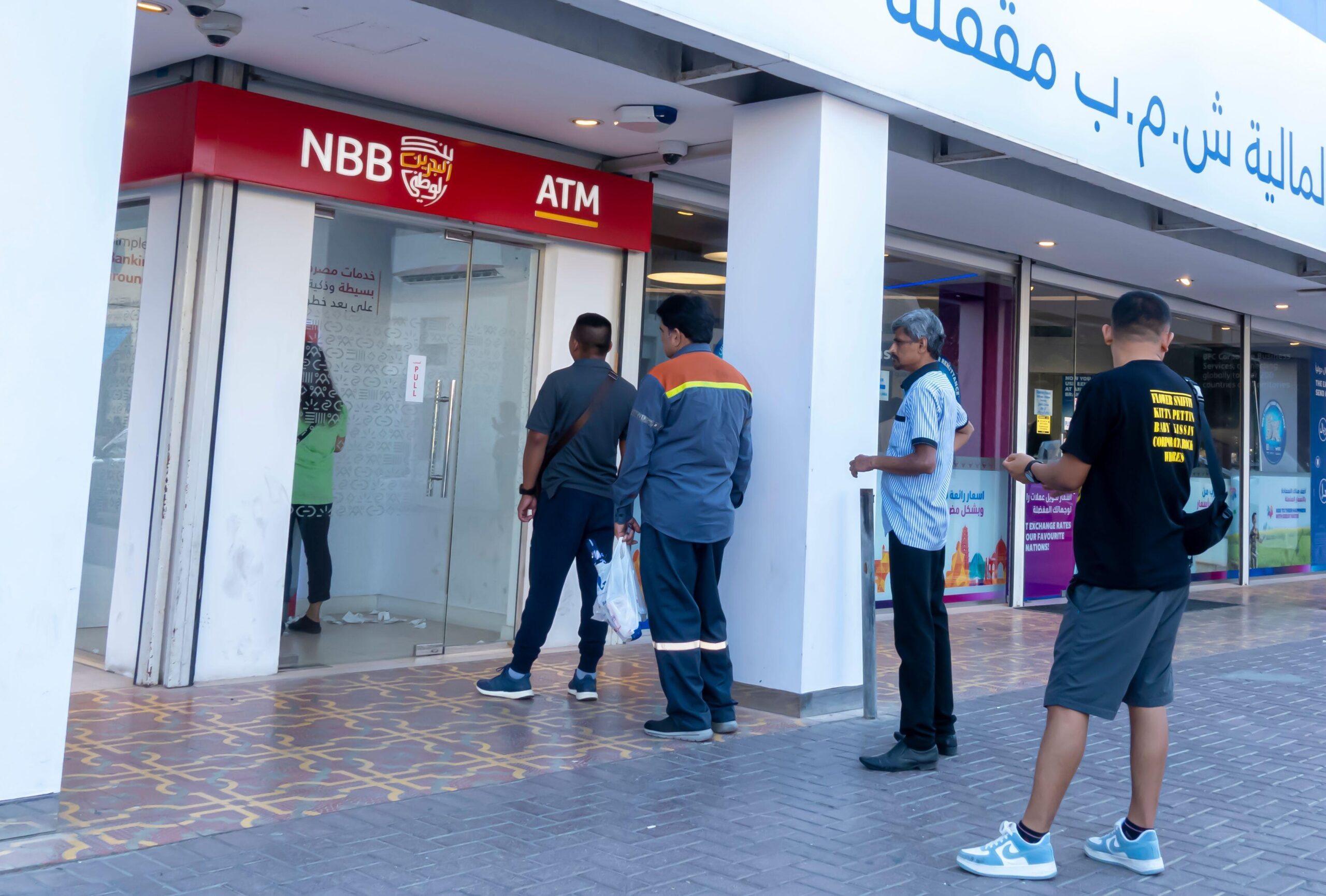 People queueing to use a National Bank of Bahrain ATM in Manama. The merger with Bank of Bahrain and Kuwait was announced this year