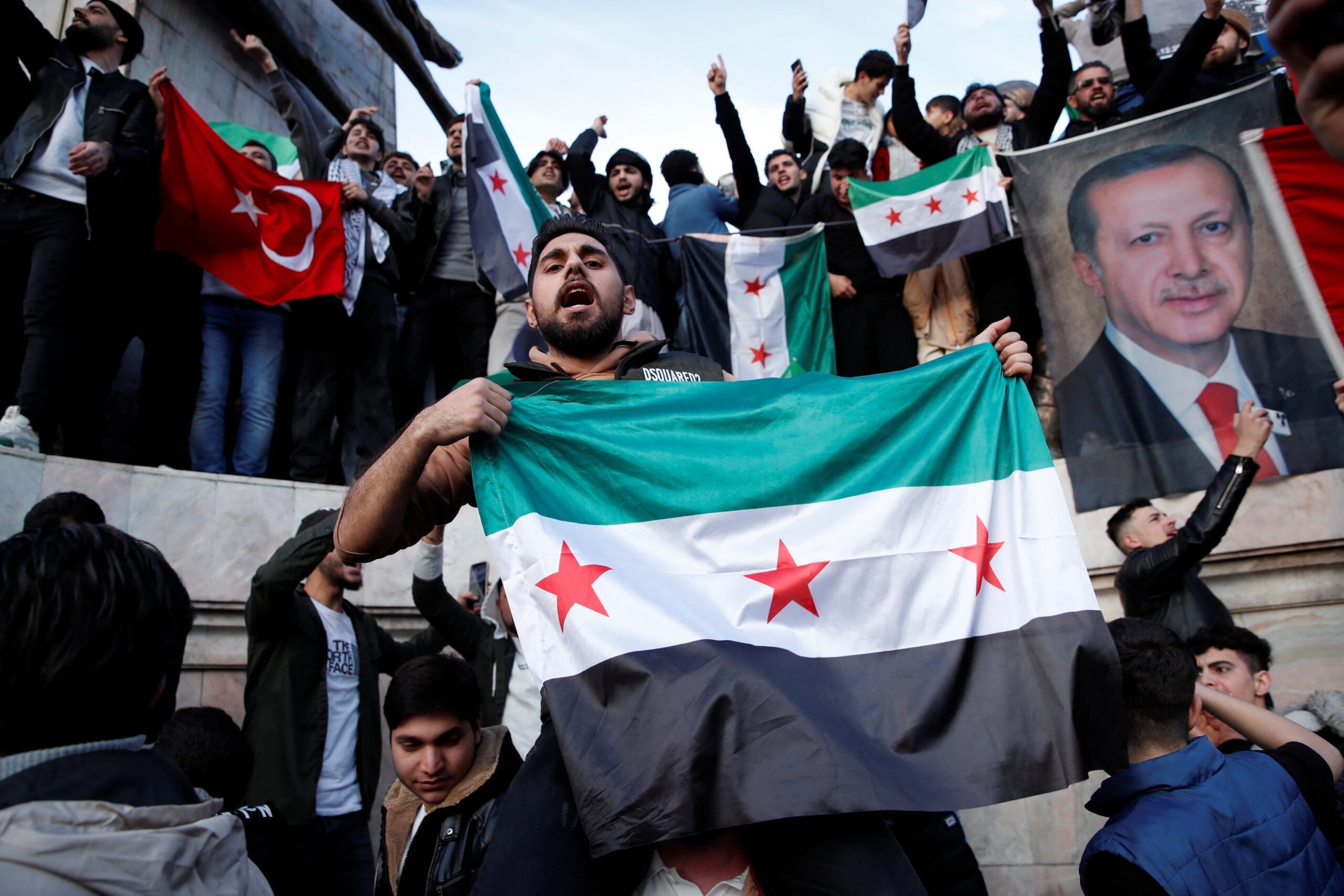 Syrians living in Istanbul hold a picture of Turkey's President Erdoğan as they celebrate the fall of Syria's President Assad