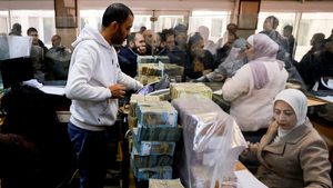 People wait as employees work at the Syrian central bank in Damascus