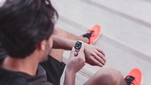 A jogger checks his smartwatch. Revibe sells watches, phones and other devices