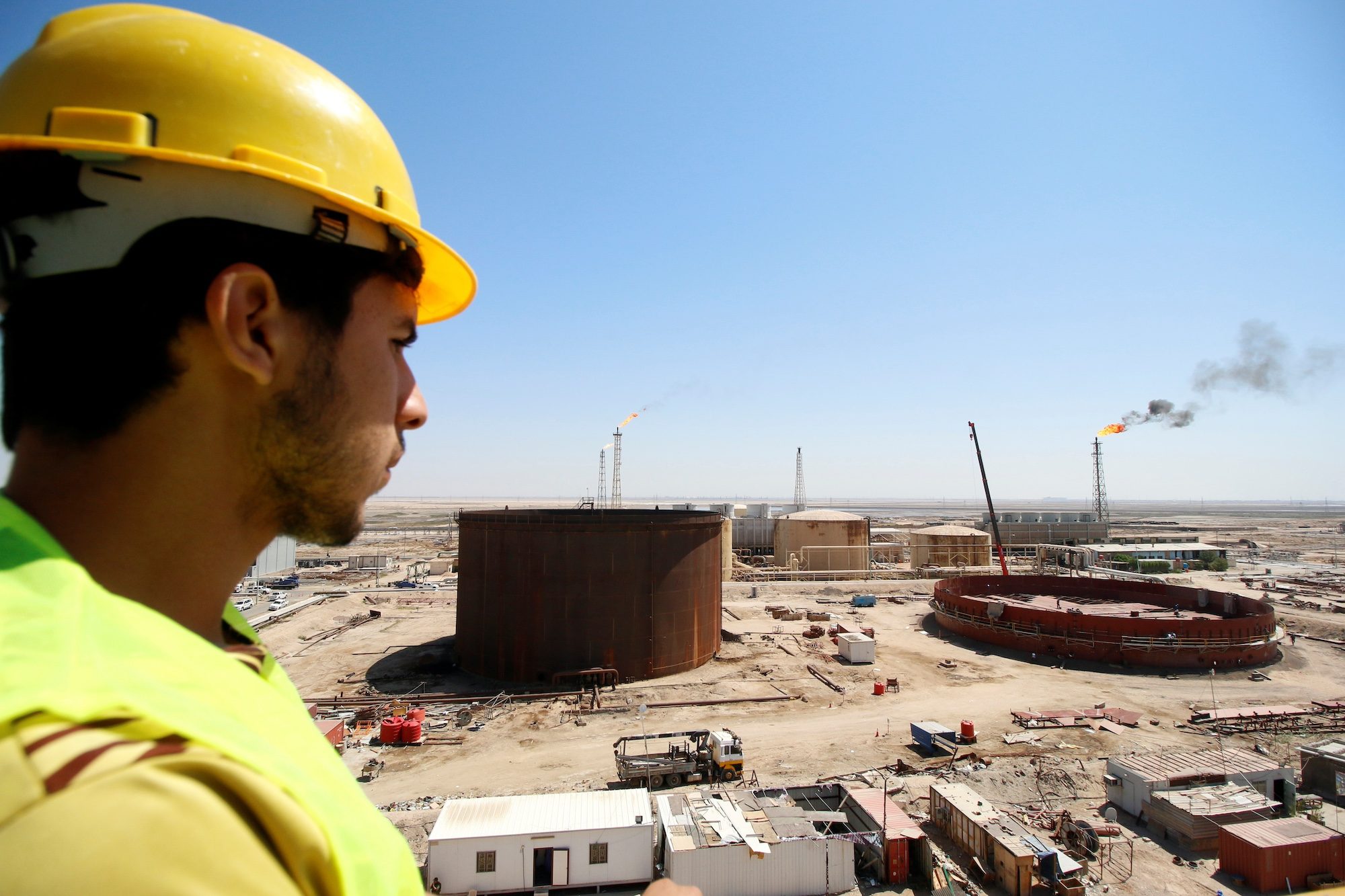 An Iraqi worker looks at the Shuaiba oil refinery in southwest Basra; Iraq is on a drive expand and update its refineries to meet a steady rise in demand