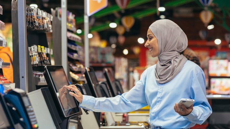A shopper uses her phone to pay for goods at the supermarket. Only one in six of purchases in the UAE are made in cash
