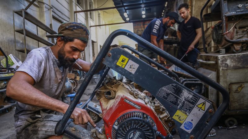 A worker repairs a portable home generator in a Baghdad workshop. Many Iraqis rely on dirty, noisy diesel generators to beat blackouts energy power electricity