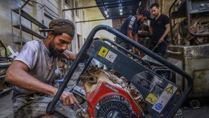 A worker repairs a portable home generator in a Baghdad workshop. Many Iraqis rely on dirty, noisy diesel generators to beat blackouts energy power electricity