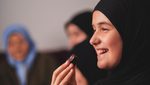 2SRYT40 Happy Muslim family having iftar dinner during Ramadan smiling daughter girl eating dates to break fast eid mubarak.