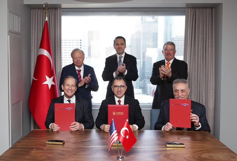 Oil company executives sign the oil and gas deal in the presence of Turkish energy minister Alparslan Bayraktar (centre standing)