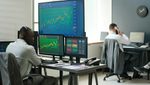Two men working in finance at computers displaying charts. Derayah Financial CEO Mohammed AlShammas believes its listing will encourage other local and regional players to do the same