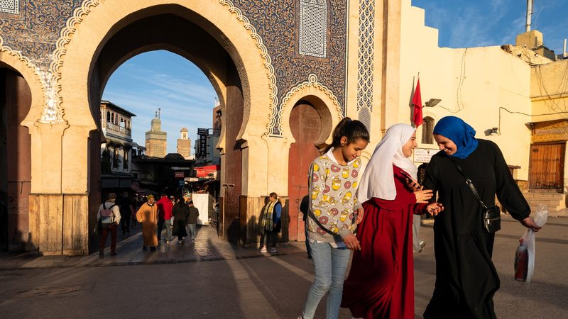 Young ladies walk out of the Bab Bou Jeloud also known as the Blue Gate which is one entrance of the medina of Fes el-Bali in Morocco on the February 17 2025. The door is blue on the outside or west but green on the other side. Des jeunes filles sortent de la Bab Bou Jeloud egalement connue sous le nom de Porte Bleue qui delimite la medina de Fes el-Bali au Maroc le 17 fevrier 2025. La porte est bleue sur l exterieur soit l ouest mais verte sur l autre versant.