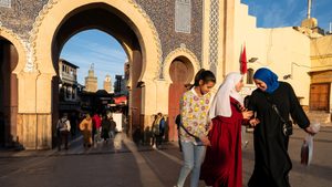 Young ladies walk out of the Bab Bou Jeloud also known as the Blue Gate which is one entrance of the medina of Fes el-Bali in Morocco on the February 17 2025. The door is blue on the outside or west but green on the other side. Des jeunes filles sortent de la Bab Bou Jeloud egalement connue sous le nom de Porte Bleue qui delimite la medina de Fes el-Bali au Maroc le 17 fevrier 2025. La porte est bleue sur l exterieur soit l ouest mais verte sur l autre versant.