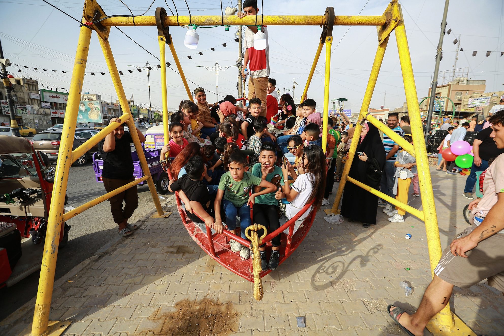 Children play on a swing in Baghdad's Sadr district. Shandong Construction Company will initially build 11,000 homes in the area