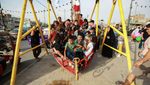Children play on a swing in Baghdad's Sadr district. Shandong Construction Company will initially build 11,000 homes in the area