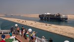 Passengers on a cruise ship watch container vessels in the Suez Canal. Egypt's GDP is projected to grow at 5%
