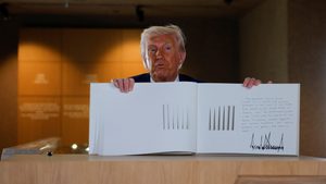 US President Donald Trump holds a guestbook as he visits the Abrahamic Family House in Abu Dhabi during the final stop of his Gulf visit