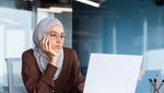 2M92198 Serious bored businesswoman inside office, muslim woman in hijab thinking while sitting at workplace with laptop, woman at work thinking about decisions. female-led, woment-led, female, woman