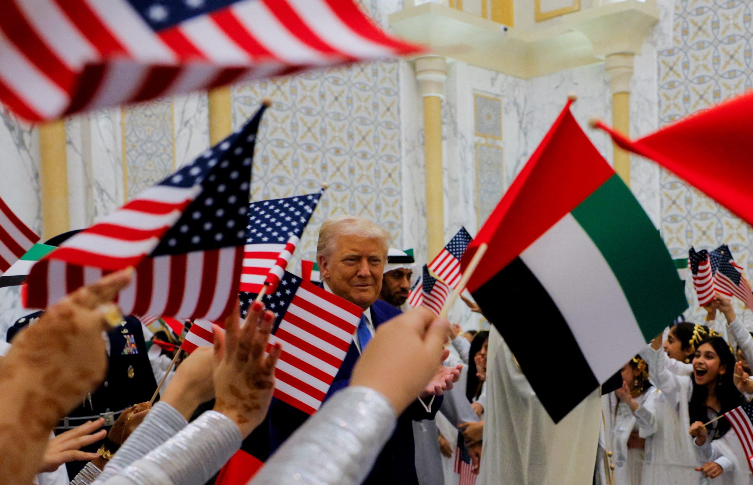 President Donald Trump is greeted by children waving flags at Qasr Al Watan in Abu Dhabi. The US-UAE partnership on AI stands out among the deals signed during his trip