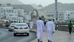 HTX2YD A pair of local Omani men walk along Muttrah corniche in the evening, in Muscat, Oman