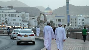 HTX2YD A pair of local Omani men walk along Muttrah corniche in the evening, in Muscat, Oman