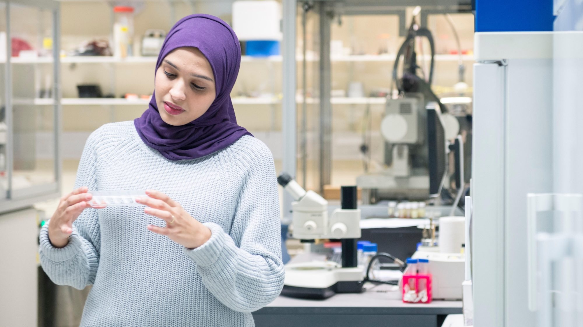 T0EC2E A muslim woman uses the scientific equipment in a research laboratory, at the University of Sussex while wearing a traditional hijab. Abu Dhabi air