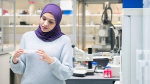 T0EC2E A muslim woman uses the scientific equipment in a research laboratory, at the University of Sussex while wearing a traditional hijab. Abu Dhabi air