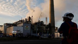 A worker at an ExxonMobil oil refinery. The company has maintained its capex guidance and will work with Adnoc