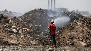 A worker extinguishes a fire at a Baghdad rubbish dump. Iraq plans to build waste-to-energy plants around the country