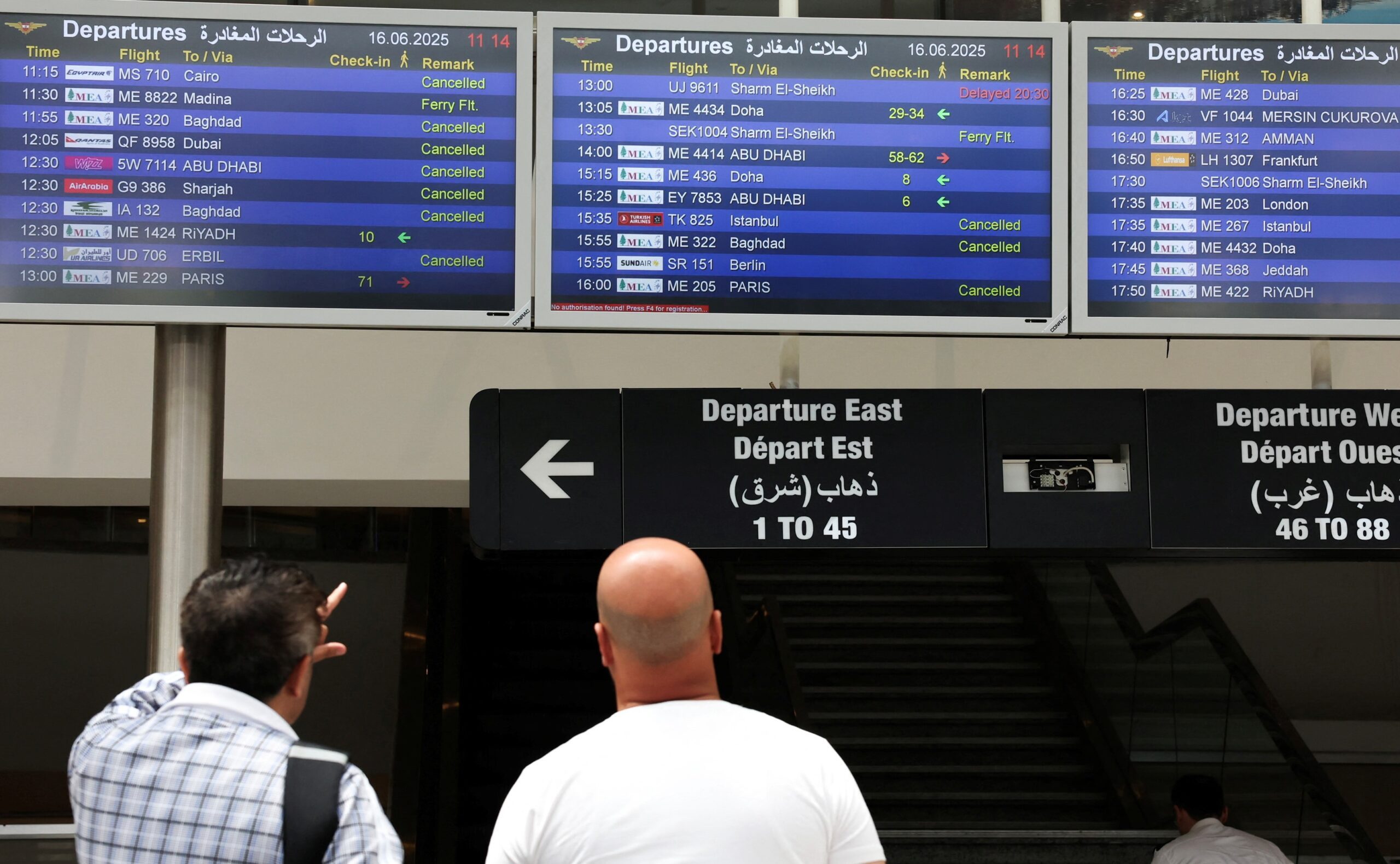 People check display screens showing cancelled flights at Lebanon's Beirut-Rafic Hariri International Airport