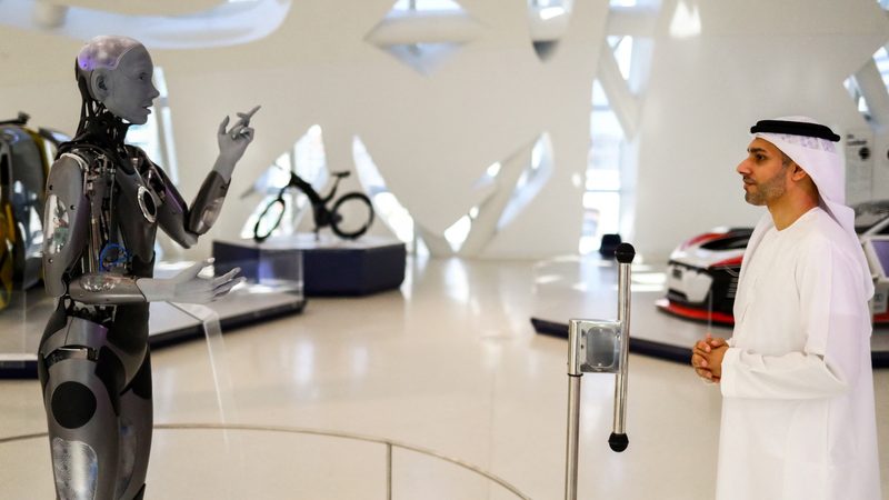 Ameca, a humanoid robot and member of the Museum of the Future staff interacts with the museum’s deputy executive director, Majed Al Mansoori in Dubai,