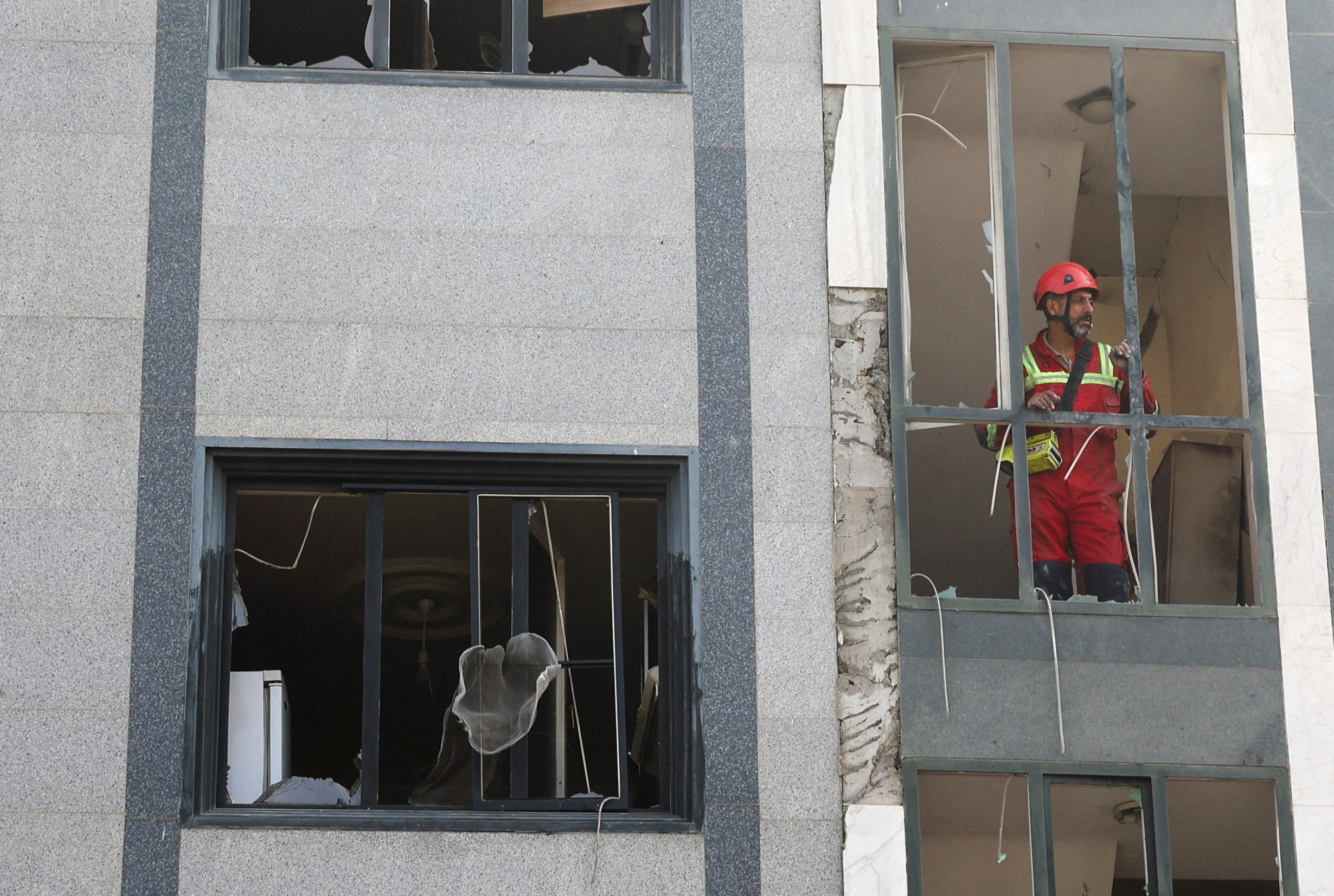 A rescuer looks out from a damaged building in the aftermath of Israeli strikes in Tehran