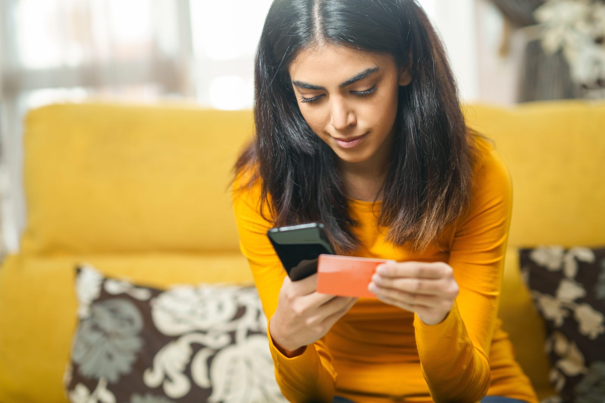 2ANN0R0 Woman shopping with smartphone paying with her credit card As buy-now-pay-later adoption outpaces credit cards, traditional banks are under pressure to adapt or risk losing a generation of borrowers