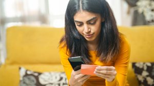 2ANN0R0 Woman shopping with smartphone paying with her credit card As buy-now-pay-later adoption outpaces credit cards, traditional banks are under pressure to adapt or risk losing a generation of borrowers