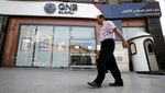 A man walks in front of the QNB Alahli Bank, in Cairo, Egypt. Only about 10 percent of Qatar’s 3.1 million people are nationals, with expatriates commonly remitting much of their income interest rates