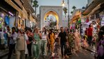 A group of people enter through the "Bab Al Fahs" on a street in the medina of Tangier in Morocco. Saudi Arabia