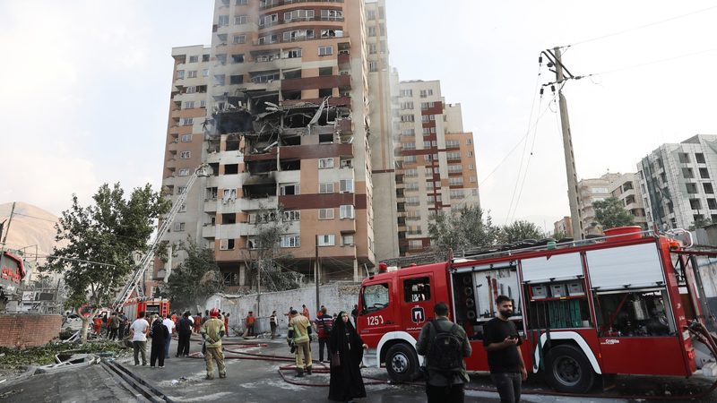 Firefighters at a damaged building in the aftermath of Israeli strikes, in Tehran, Iran