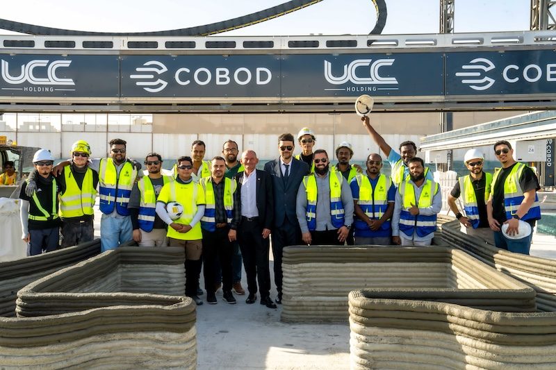 Workers celebrate the start of construction for 3D-printed buildings, part of a larger school-building project in Qatar