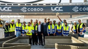 Workers celebrate the start of construction for 3D-printed buildings, part of a larger school-building project in Qatar