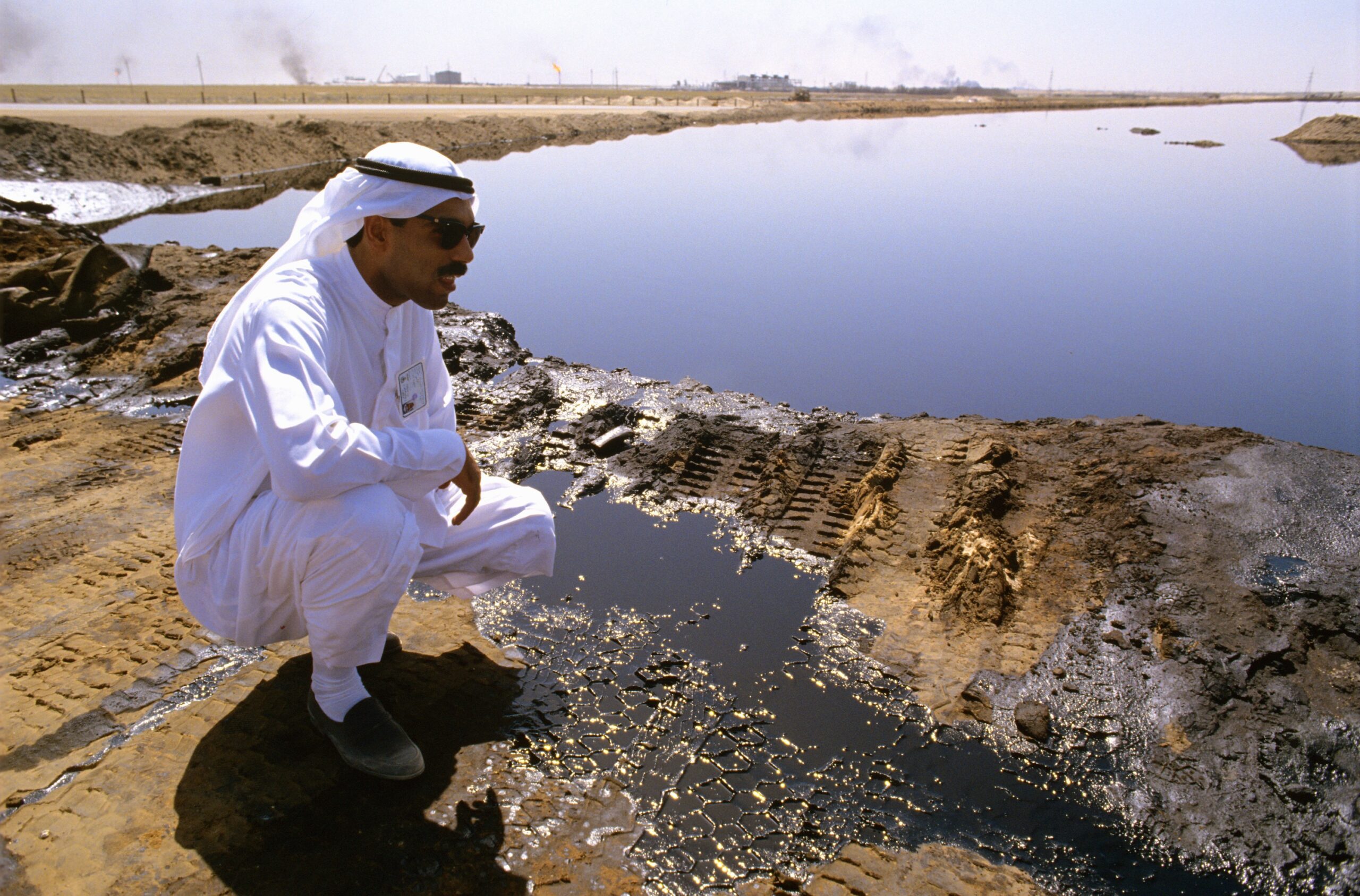 A worker checks a Kuwaiti oil lake